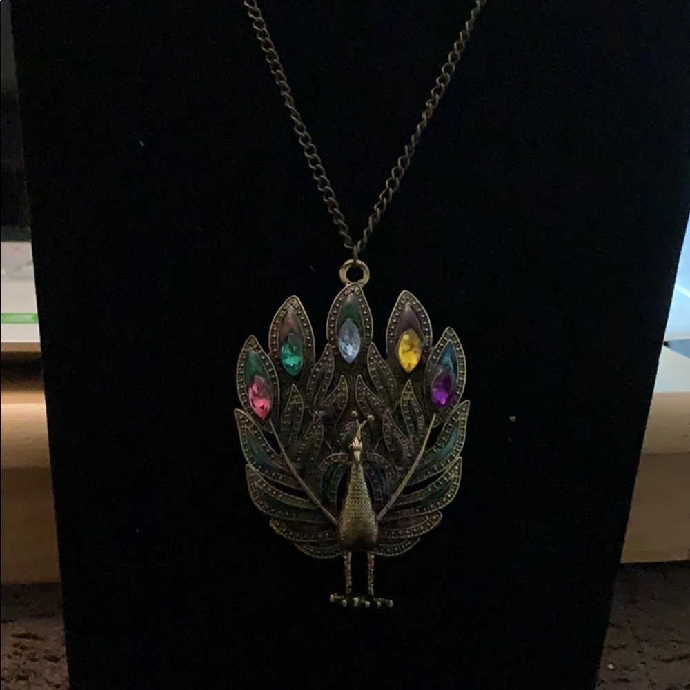 Peacock standing with five stones & green feathers
